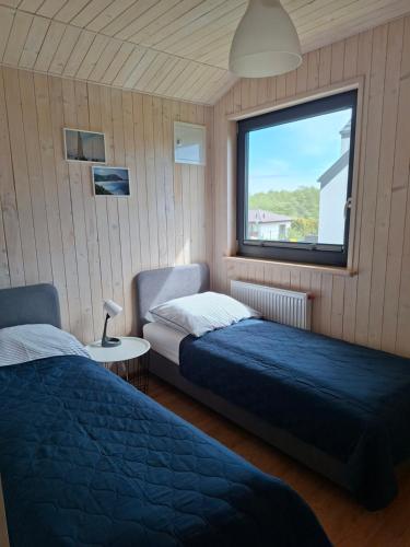 a bedroom with two beds and a window at Perła Szotlandu II in Władysławowo