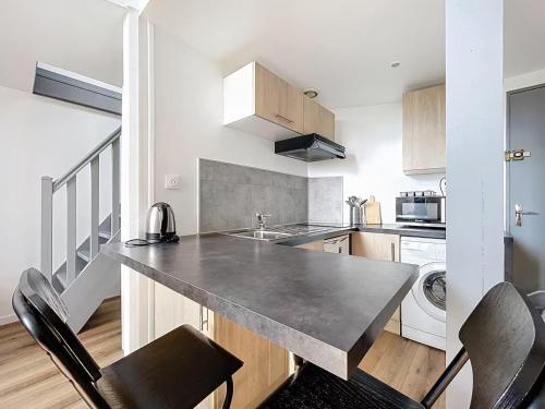 - une cuisine avec un comptoir et quelques chaises dans l'établissement La Capsule, à Rouen