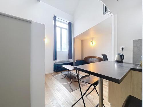 une salle à manger avec une table et quelques chaises dans l'établissement La Capsule, à Rouen