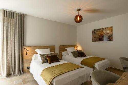 une chambre avec deux lits et un ventilateur de plafond dans l'établissement Domaine Saint Georges, à Saint-Sauveur-le-Vicomte