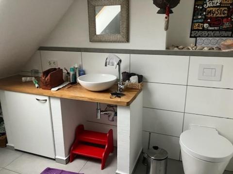 bagno con lavandino e sgabello rosso di Natur, Kultur und Wandern a Losheim