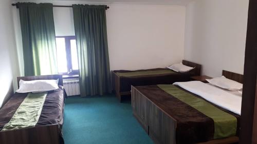 a hotel room with two beds and a window at Гостевой дом Алма in Borovoye