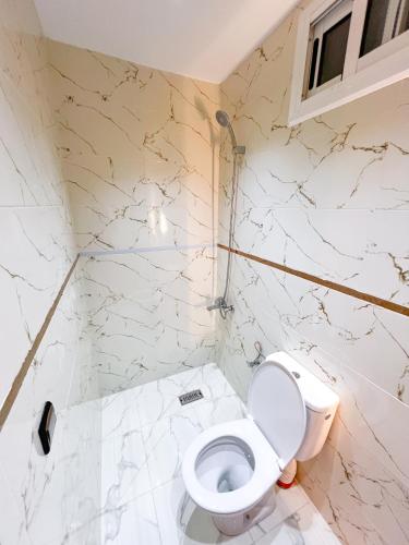 a bathroom with a toilet and marble walls at Visit Chamal - Zaphir in Oued Laou