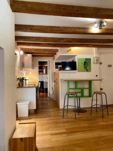 - une cuisine avec une table et deux tabourets dans une pièce dans l'établissement Studio calme - pentes de la croix rousse, à Lyon