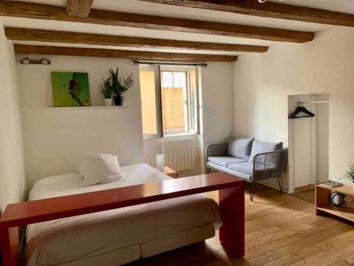 une chambre avec un lit, un canapé et une fenêtre dans l'établissement Studio calme - pentes de la croix rousse, à Lyon