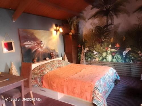 une chambre avec un lit avec un tableau sur le mur dans l'établissement D'Ici ou D'ailleurs, à Barneville-Carteret