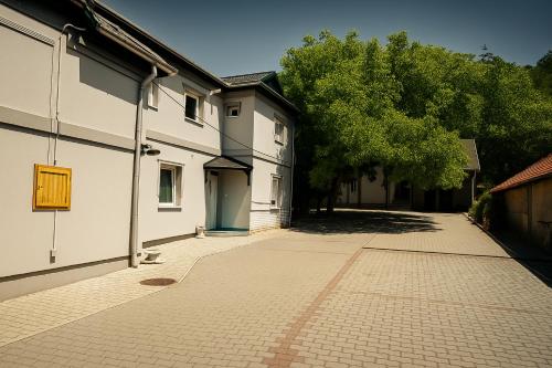 an empty alley with a building and trees at Zöld Sziget Üdülőház in Egerszalók