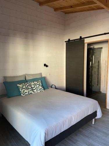 Ce lit se trouve dans un dortoir doté d'un grand lit blanc. dans l'établissement La cabane des Esteys, à Arès