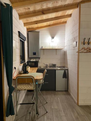 - une petite cuisine avec une table et un comptoir dans l'établissement La cabane des Esteys, à Arès