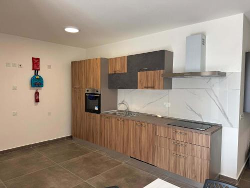 a kitchen with wooden cabinets and a counter top at Spacious Stay new 2 Bed and Balcony in Taʼ Penza