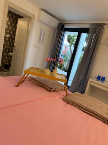a bedroom with a bed with a table on it at Wtite Sea 2 in Kavála