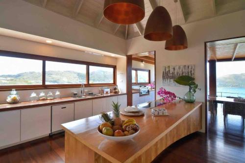 a kitchen with a table with a bowl of fruit on it at Destiny Le Rêve Bleu et la Mer in Bequia