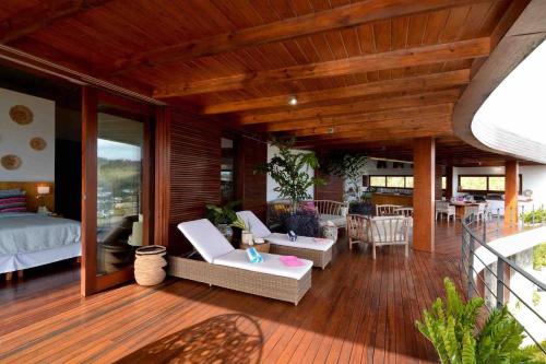a room with a bed and chairs on a deck at Destiny Le Rêve Bleu et la Mer in Bequia