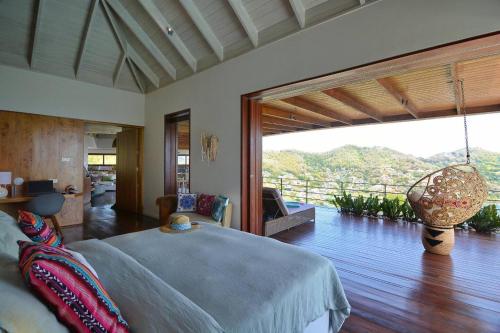 a bedroom with a bed and a large window at Destiny Le Rêve Bleu et la Mer in Bequia