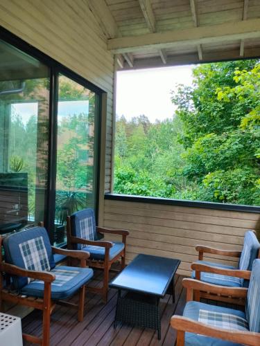 a porch with chairs and a table and windows at 3 room apartment&terrace in Espoo