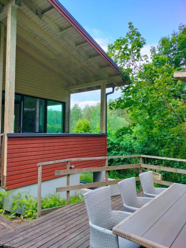 a deck with a table and chairs on a house at 3 room apartment&terrace in Espoo