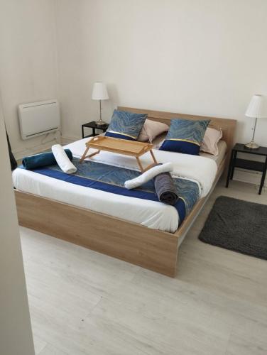 Cette chambre comprend un grand lit avec un cadre en bois. dans l'établissement Grande maison BREST, à Brest