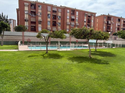 two trees in the grass in front of a building at El Mirador de Linarejos in Linares