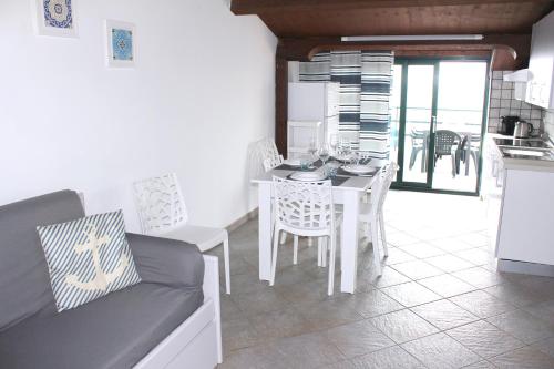 a kitchen and dining room with a table and chairs at Villa Anita Apartments in Capo dʼOrlando