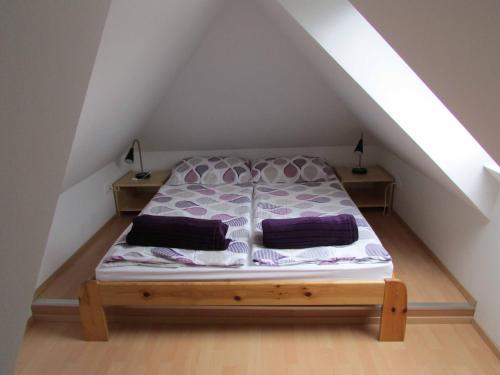 a bed with two pillows on it in a attic at Apartment Iris in Bohinj