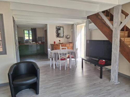 un salon avec une table et une télévision dans l'établissement Cottage au calme avec parking privé, à Lavoux