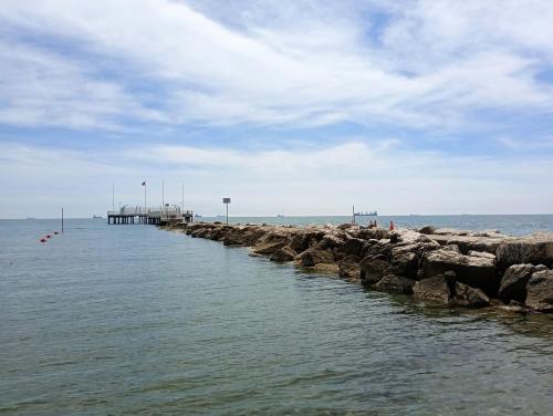 a pier in the ocean with rocks in the water at Hotel Cristallo in Venice-Lido