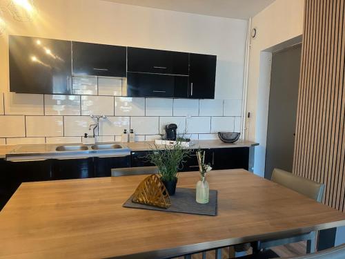 - une cuisine avec une table en bois et un comptoir dans l'établissement L'Échappée Belle Amandinoise, à Saint-Amand-les-Eaux