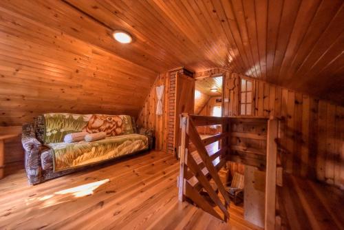 a room with a couch in a log cabin at Drzemalik wypoczywaj z KLASĄ in Skarlin