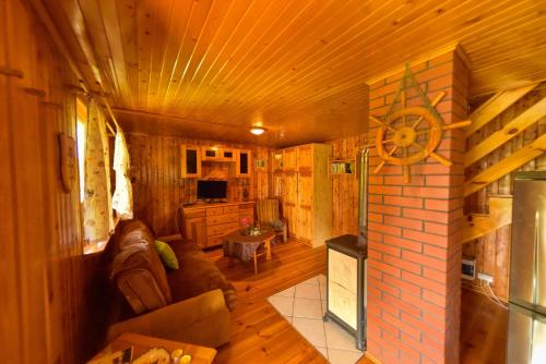 a living room of a log cabin with a fireplace at Drzemalik wypoczywaj z KLASĄ in Skarlin