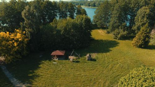 a small cabin in the middle of a field with a lake at Drzemalik wypoczywaj z KLASĄ in Skarlin