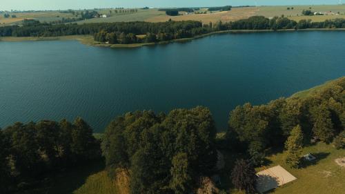 an aerial view of a lake with trees and a house at Drzemalik wypoczywaj z KLASĄ in Skarlin