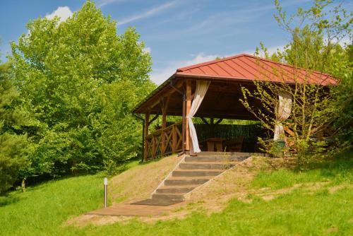 a gazebo with a red roof on a hill at Drzemalik wypoczywaj z KLASĄ in Skarlin