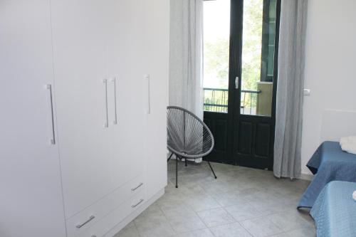 a bedroom with a bed and a chair and a window at Villa Anita Apartments in Capo dʼOrlando