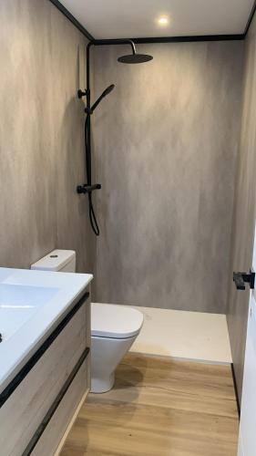 a bathroom with a white toilet and a shower at Marina View II Empuriabrava - view port in Empuriabrava