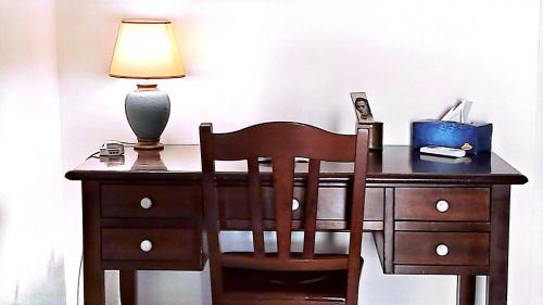 a wooden desk with a lamp and a chair at Kairòs - locazione turistica in Torre Annunziata