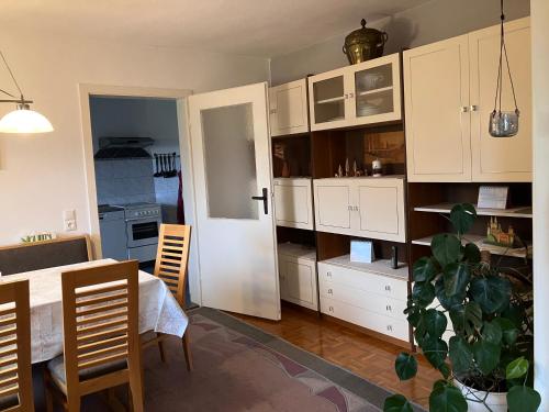 a kitchen with white cabinets and a table and a plant at Ferienwohnung Hans in Girbigsdorf
