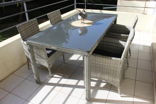 une table en verre et des chaises sur un balcon dans l'établissement Mes rêves, à Marseille