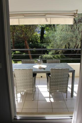 une table et des chaises sur une terrasse avec une fenêtre dans l'établissement Mes rêves, à Marseille