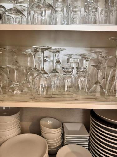 a shelf filled with glasses and plates and bowls at ｄｐ小山町 in Machida