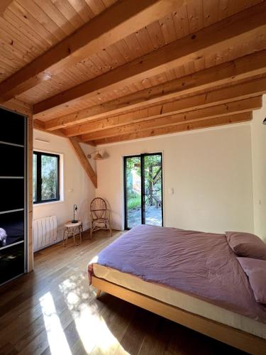 une chambre avec un grand lit dans une pièce avec des plafonds en bois dans l'établissement Seignosse Family House with Big Garden, à Seignosse