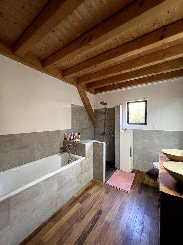 une grande salle de bain avec une baignoire et un lavabo dans l'établissement Seignosse Family House with Big Garden, à Seignosse
