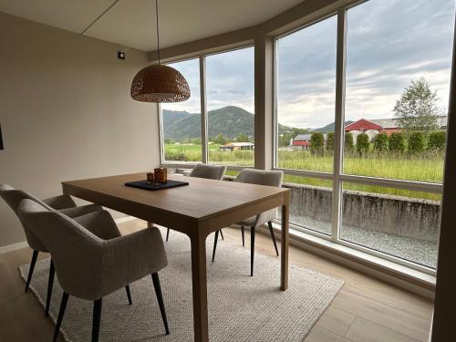 a dining room with a table and chairs and a large window at Apartment Suite in Os in Osøyro