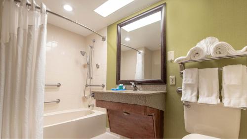 a bathroom with a tub and a sink and a toilet at Holiday Inn Express Stony Brook-Long Island by IHG in Centereach
