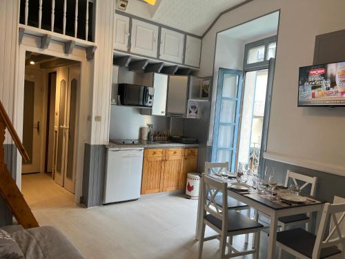 une cuisine avec une table avec des chaises et une salle à manger dans l'établissement Studio 4 personnes plein centre, à Cauterets