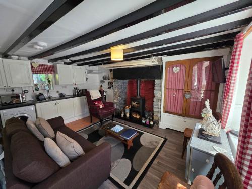 a living room with a couch and a kitchen at Pet friendly two bedroom cosy cottage in Tanygrisiau