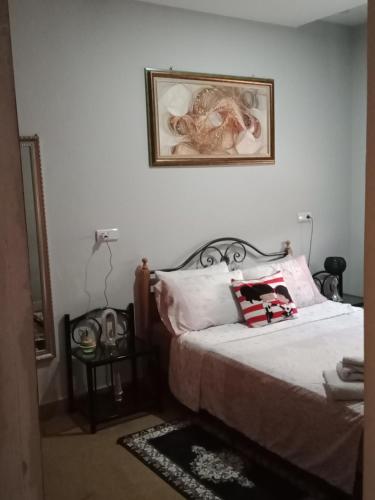 a bedroom with a bed and a picture on the wall at Appartement meublé ennasr49 in Khenifra