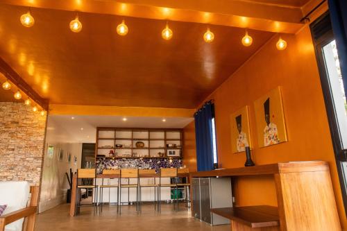 a living room with orange walls and a ceiling with lights at Green Valley Residence By Serenova Retreats in Kigali