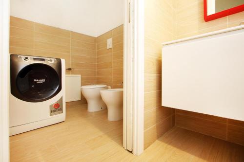 a bathroom with a washing machine and a toilet at Villa Sa Marchesa in Solanas
