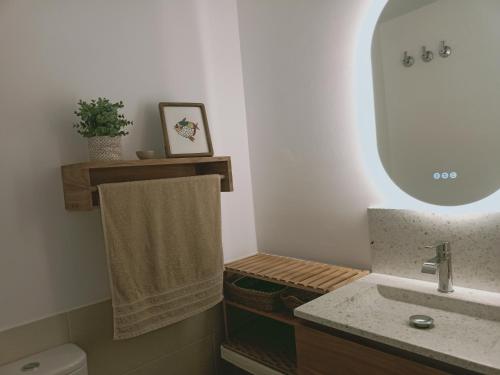 a bathroom with a sink and a mirror and a toilet at Playa y confort Zahara in Zahara de los Atunes