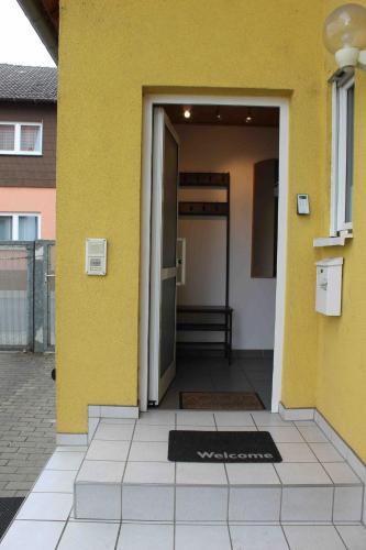 a yellow building with a door with a mat in front at Ferienhaus in Reilingen in Reilingen